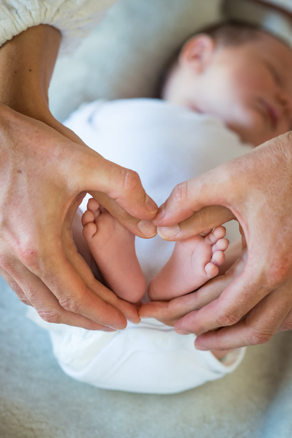 the hands of parents holding their newborn babies feet in the shape of a heart