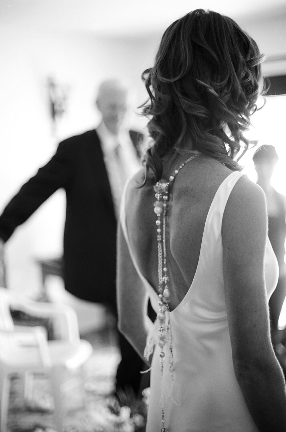 black and white photograph of the detail on the back of a bride's wedding dress at her wedding in Ibiza