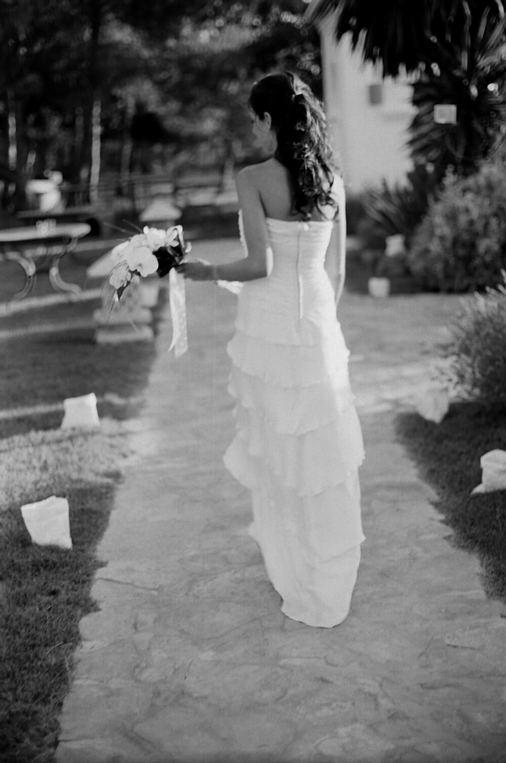 back view of a bride in her wedding dress holding her bouquet
