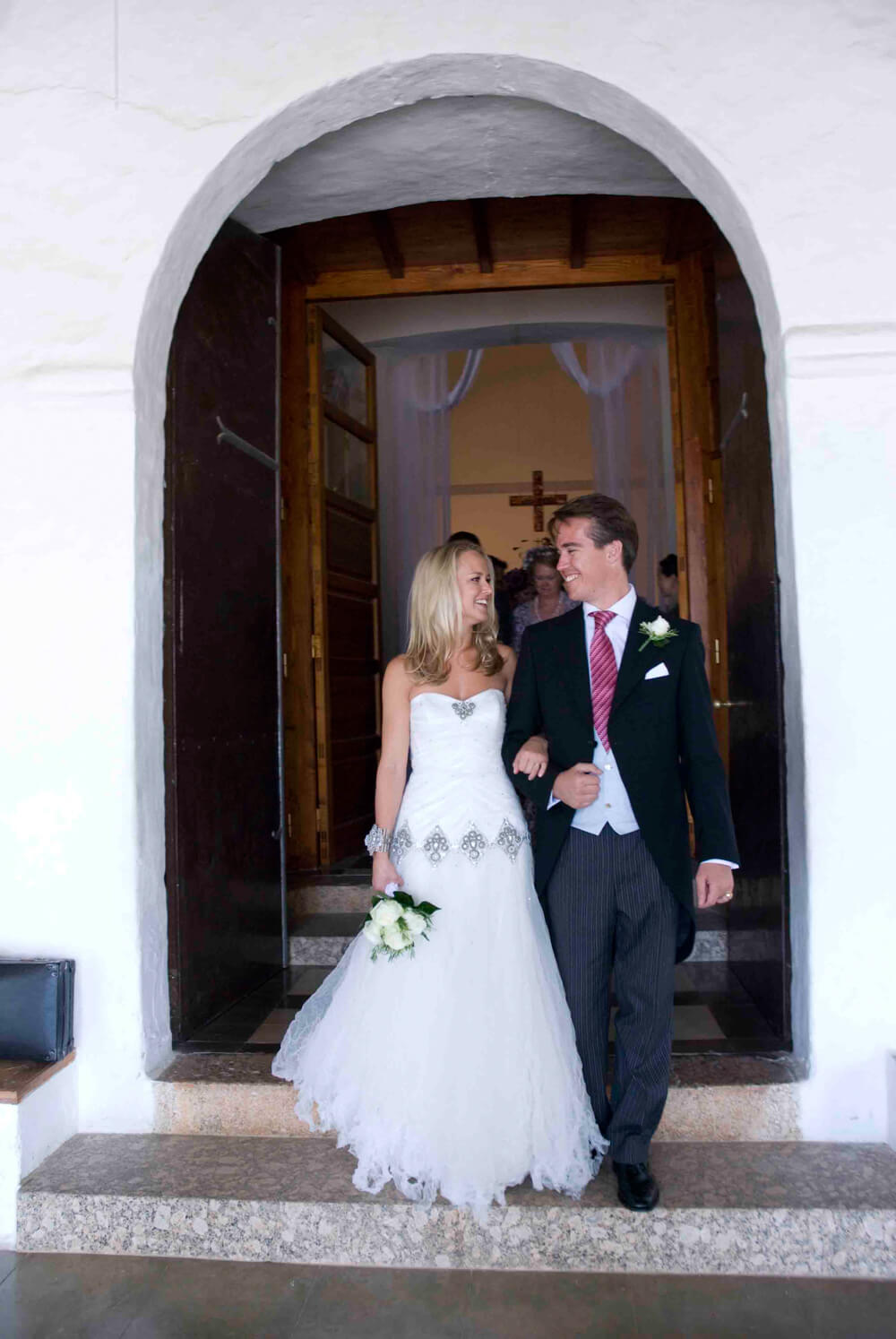 bride and groom walking out of the church at their wedding in Ibiza