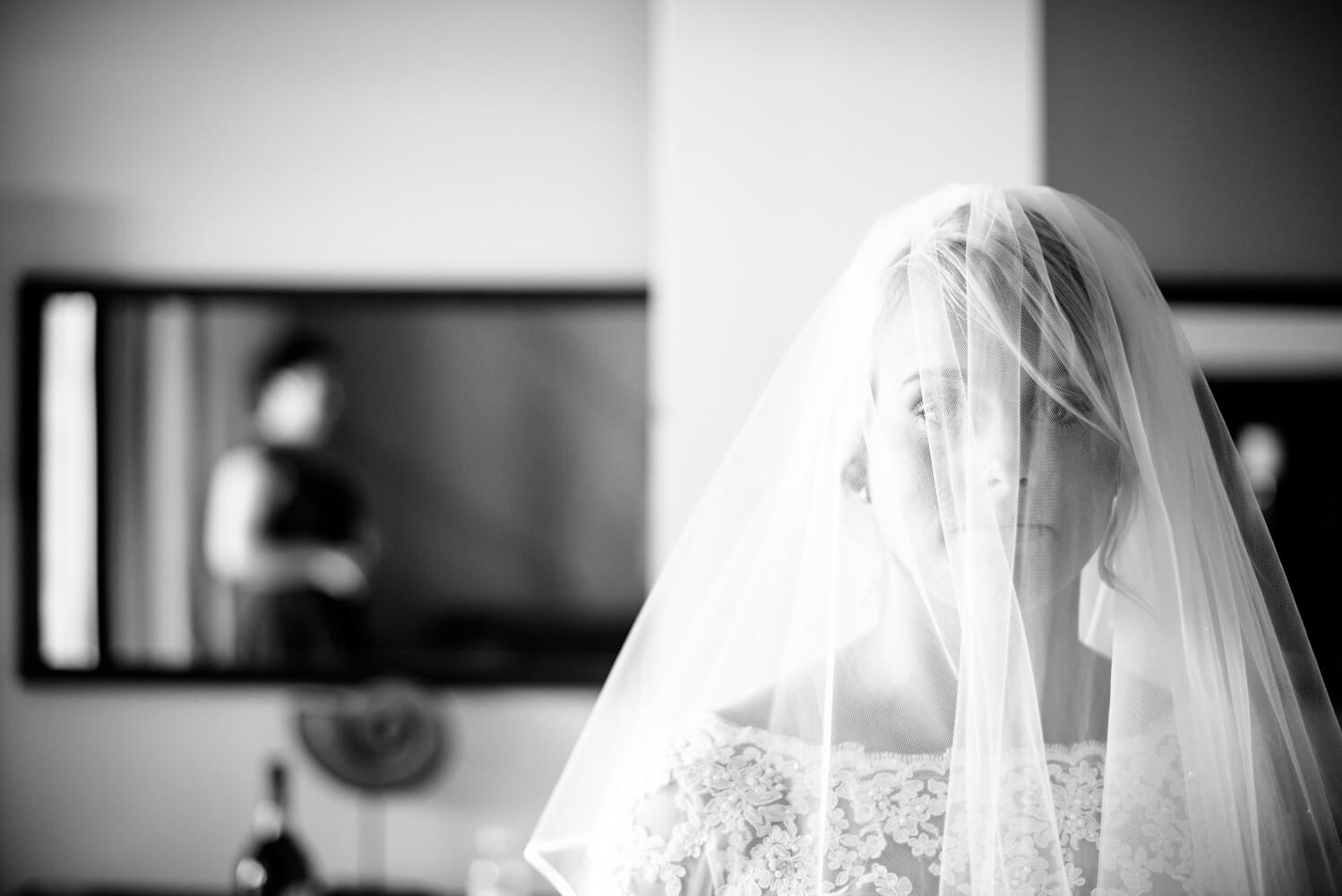 black and white photograph of a bride gazing through her veil at her wedding in Ibiza