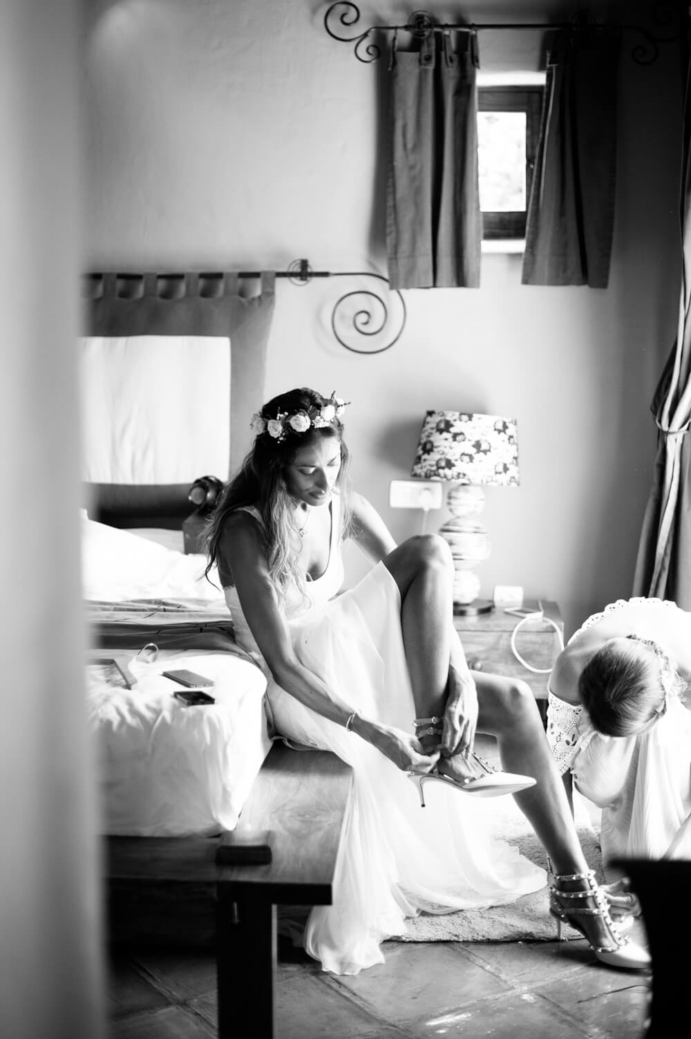 black and white photograph of a bride putting her wedding shoes on for her wedding in Ibiza