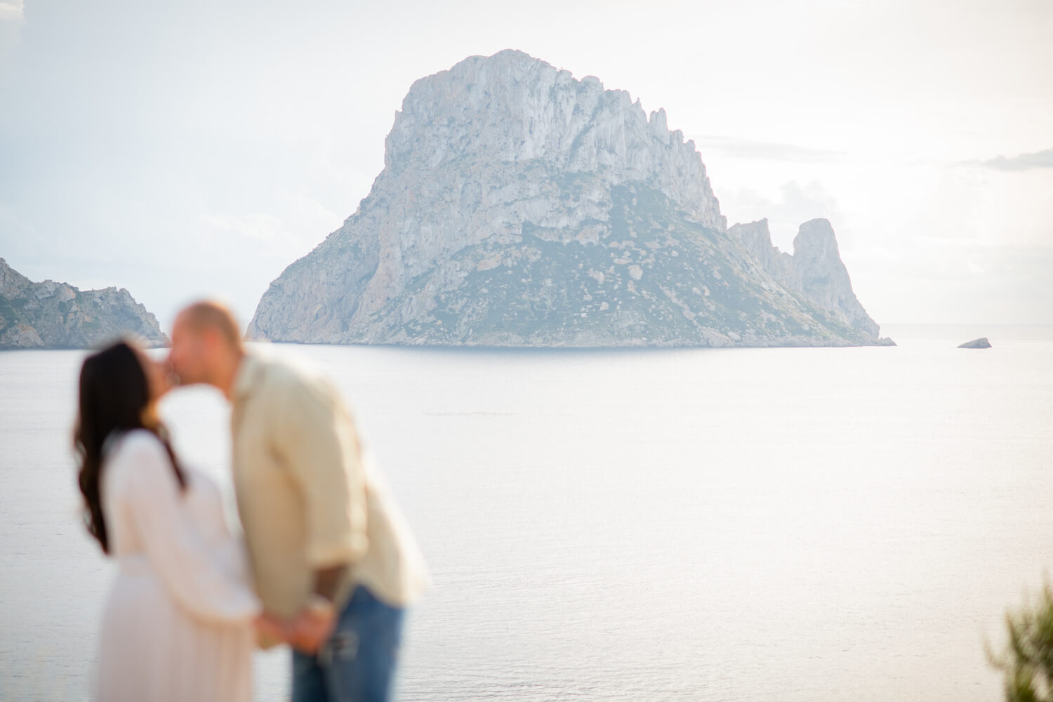 Couple kissing during their Pregnancy Shoot looking over Es Vedra