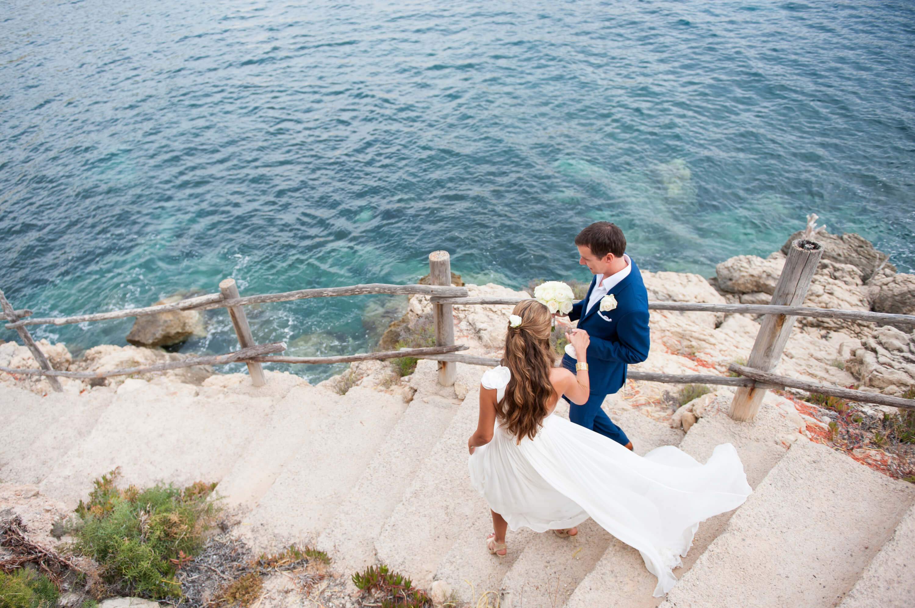 Bride and groom walking by the sea at Ibiza wedding in Es Boldado