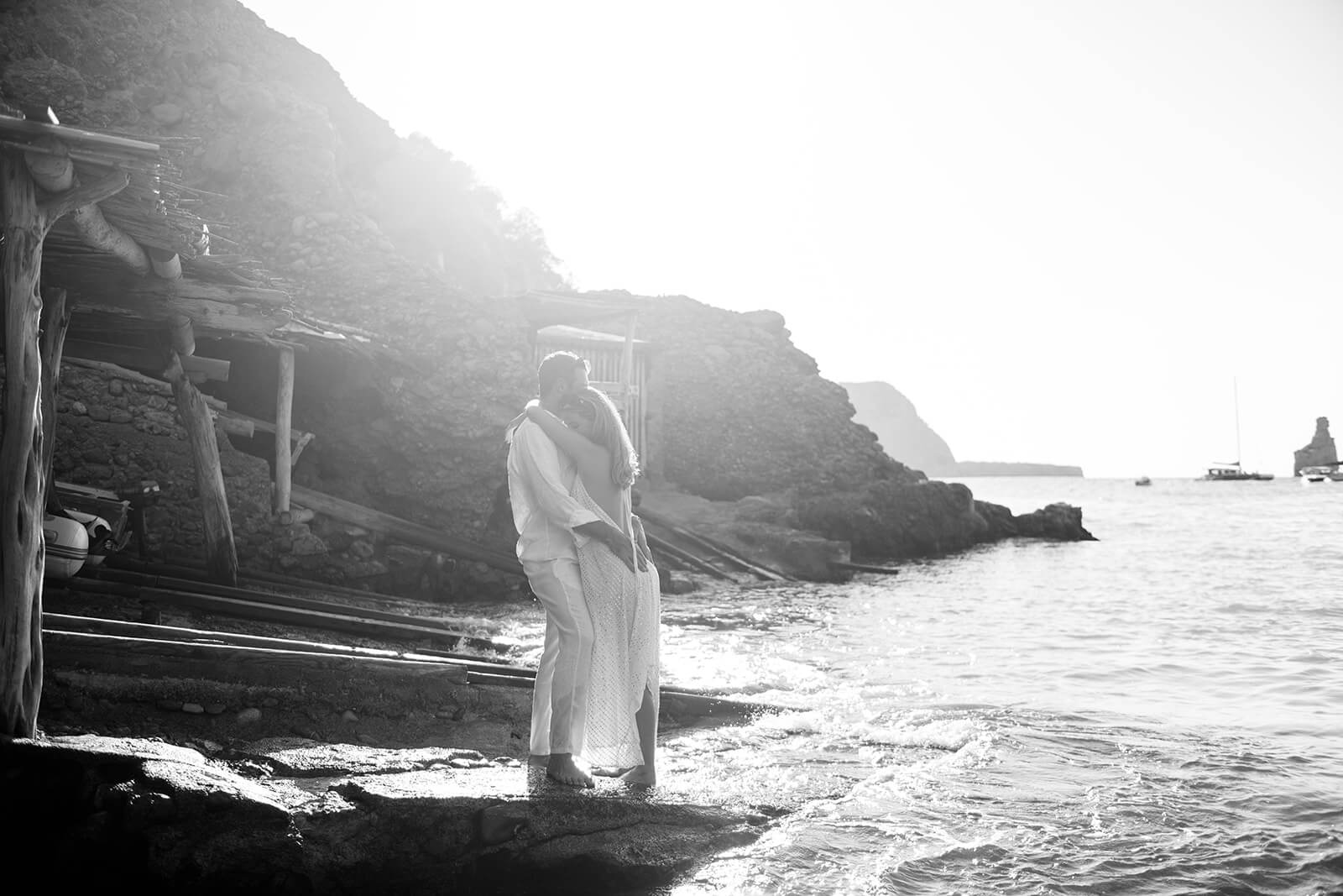 N+L _ Gypsy Westwood h-14_websize Couple stand kissing at Benirras beach in Ibiza after marriage proposal